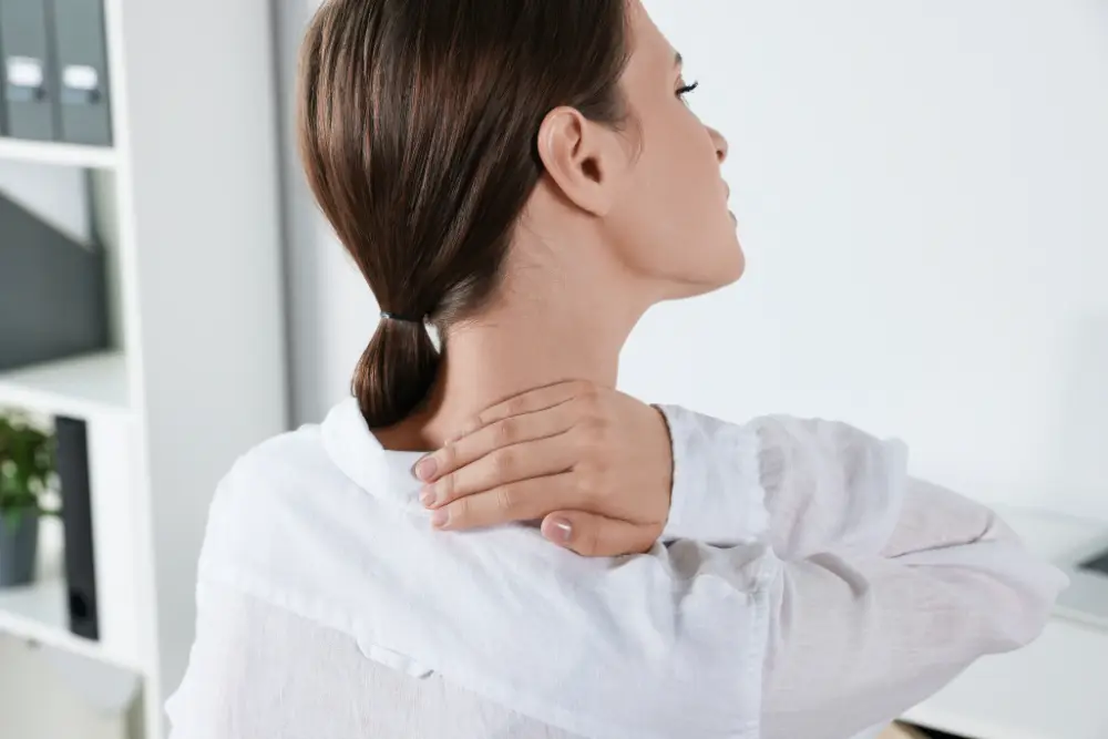 Woman holding the back of her neck in pain